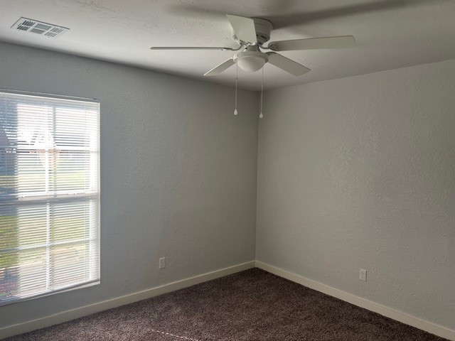 10117 Southridge Drive, Oklahoma City, OK 73159 empty room with dark carpet and ceiling fan