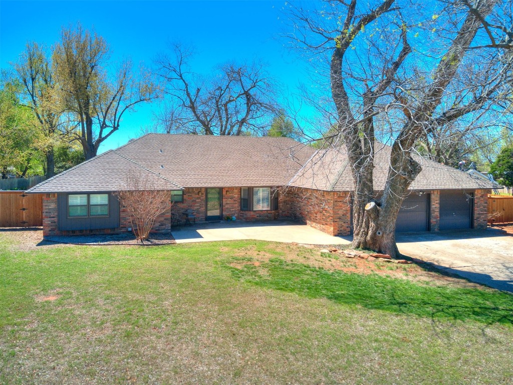 1738 W Rose Oak Drive, Mustang, OK 73064 ranch-style house featuring a front yard and a garage