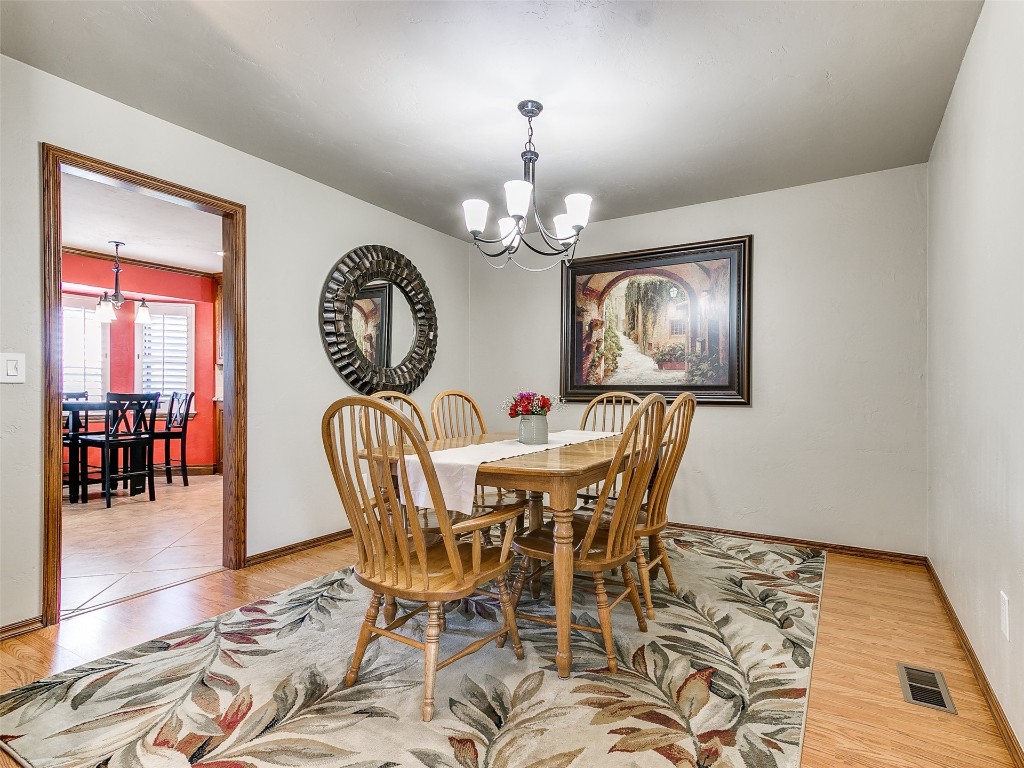 1738 W Rose Oak Drive, Mustang, OK 73064 tiled dining area with an inviting chandelier