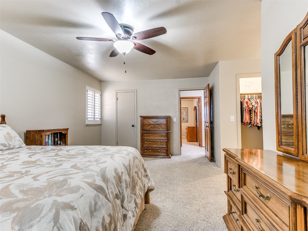1738 W Rose Oak Drive, Mustang, OK 73064 bedroom with a closet, light carpet, a spacious closet, and ceiling fan