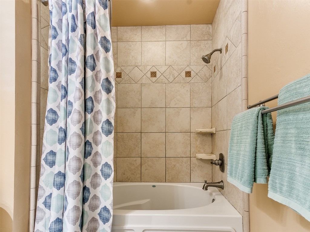 1738 W Rose Oak Drive, Mustang, OK 73064 bathroom featuring shower / tub combo with curtain