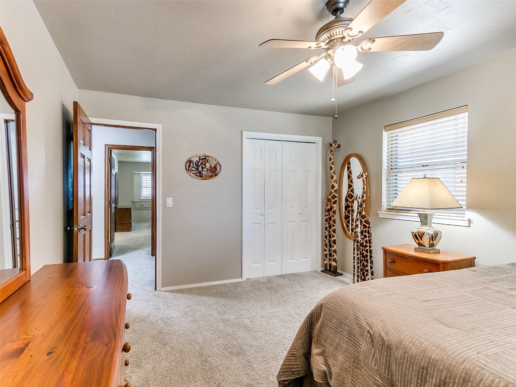 1738 W Rose Oak Drive, Mustang, OK 73064 bedroom with ceiling fan, light carpet, and a closet