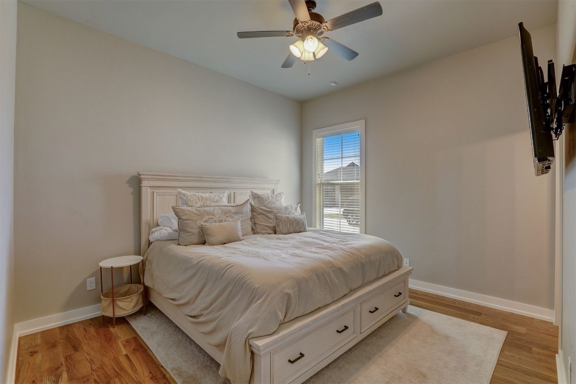 2273 NW 223rd Street, Edmond, OK 73025 bedroom with light hardwood / wood-style floors and ceiling fan