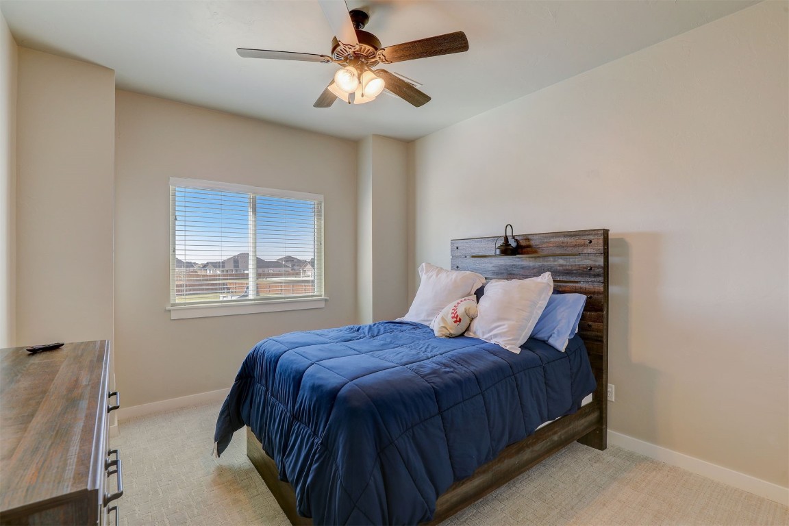 2273 NW 223rd Street, Edmond, OK 73025 bedroom with light carpet and ceiling fan