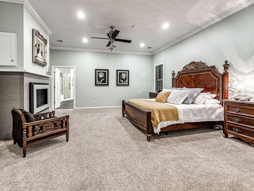 4101 Oakdale Farm Circle, Edmond, OK 73013 bedroom featuring connected bathroom, light carpet, ceiling fan, and ornamental molding