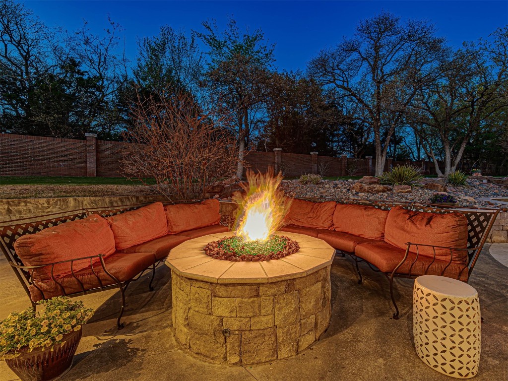 4101 Oakdale Farm Circle, Edmond, OK 73013 patio terrace at twilight with an outdoor living space with a fire pit