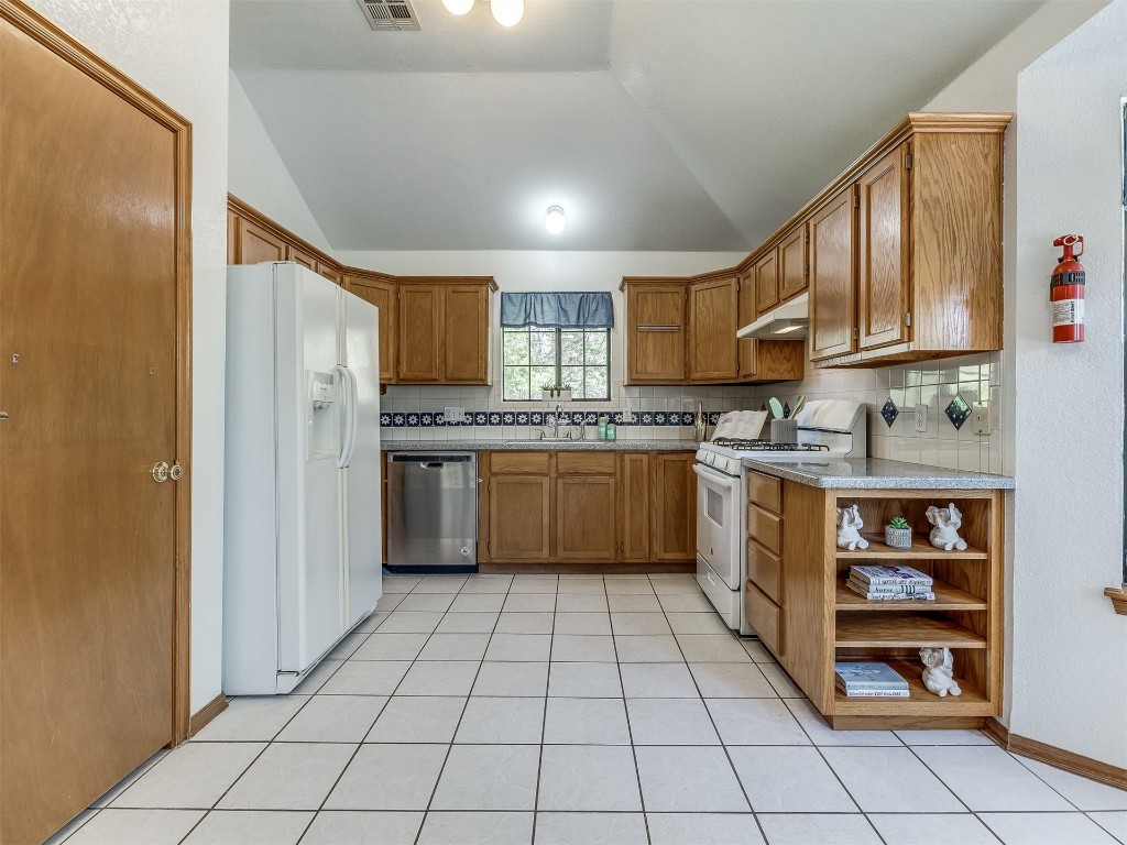 100 Parkdale Court, Noble, OK 73068 kitchen with white appliances, tasteful backsplash, and light tile floors