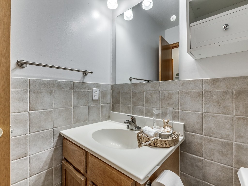 100 Parkdale Court, Noble, OK 73068 bathroom featuring tile walls, toilet, large vanity, and tasteful backsplash