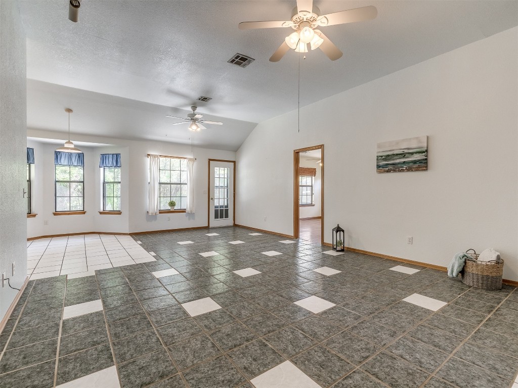 100 Parkdale Court, Noble, OK 73068 tiled empty room featuring lofted ceiling, ceiling fan, and a textured ceiling