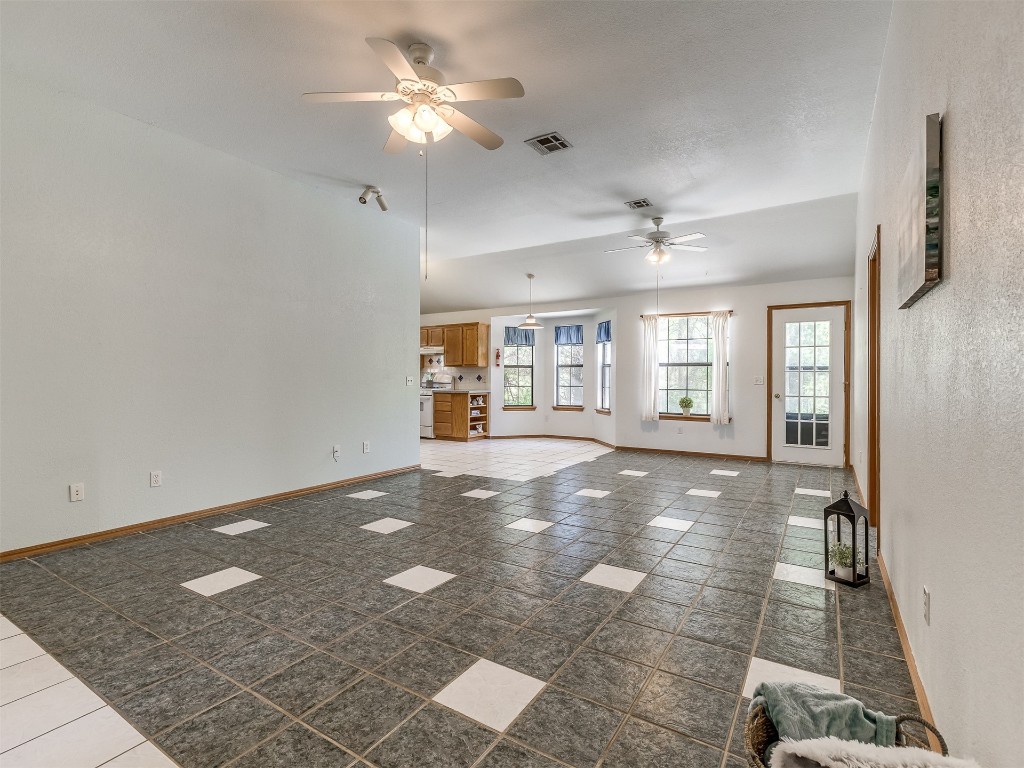 100 Parkdale Court, Noble, OK 73068 unfurnished living room featuring dark tile floors and ceiling fan