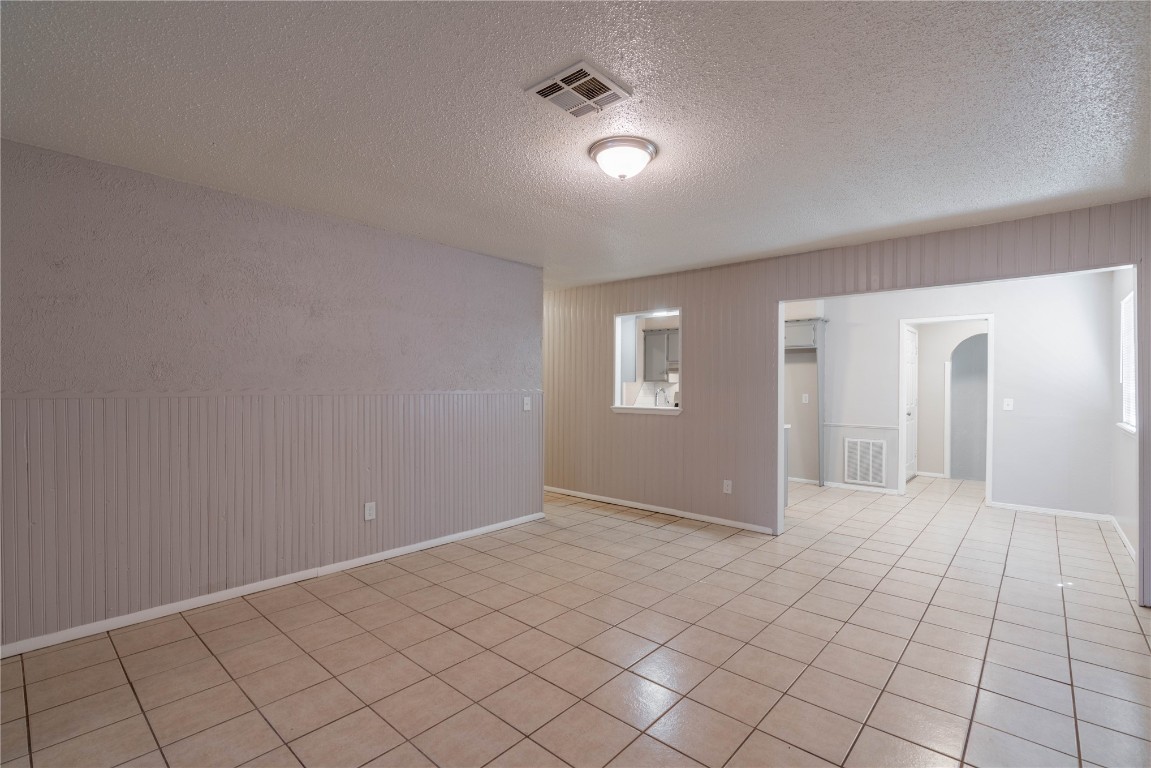 301 NW 80th Street, Oklahoma City, OK 73114 spare room with light tile floors and a textured ceiling