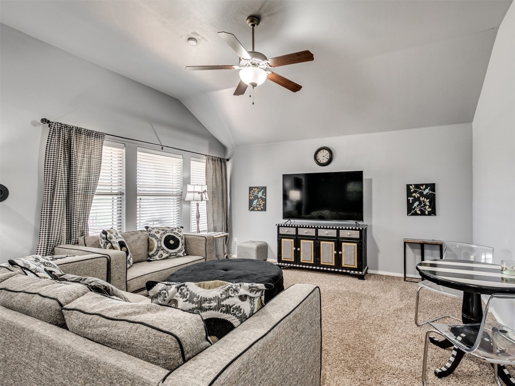 18620 Ochoa Drive, Edmond, OK 73012 carpeted living room featuring ceiling fan and lofted ceiling