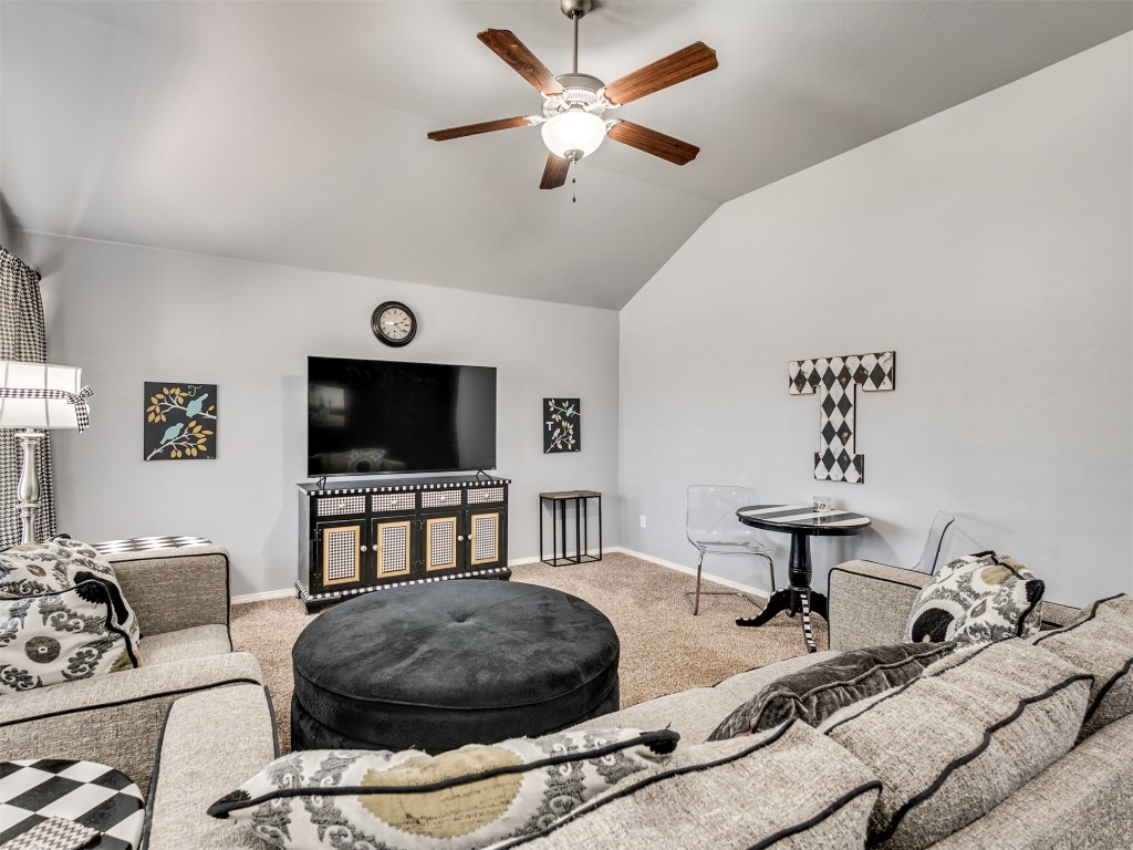 18620 Ochoa Drive, Edmond, OK 73012 living room featuring lofted ceiling, light colored carpet, and ceiling fan