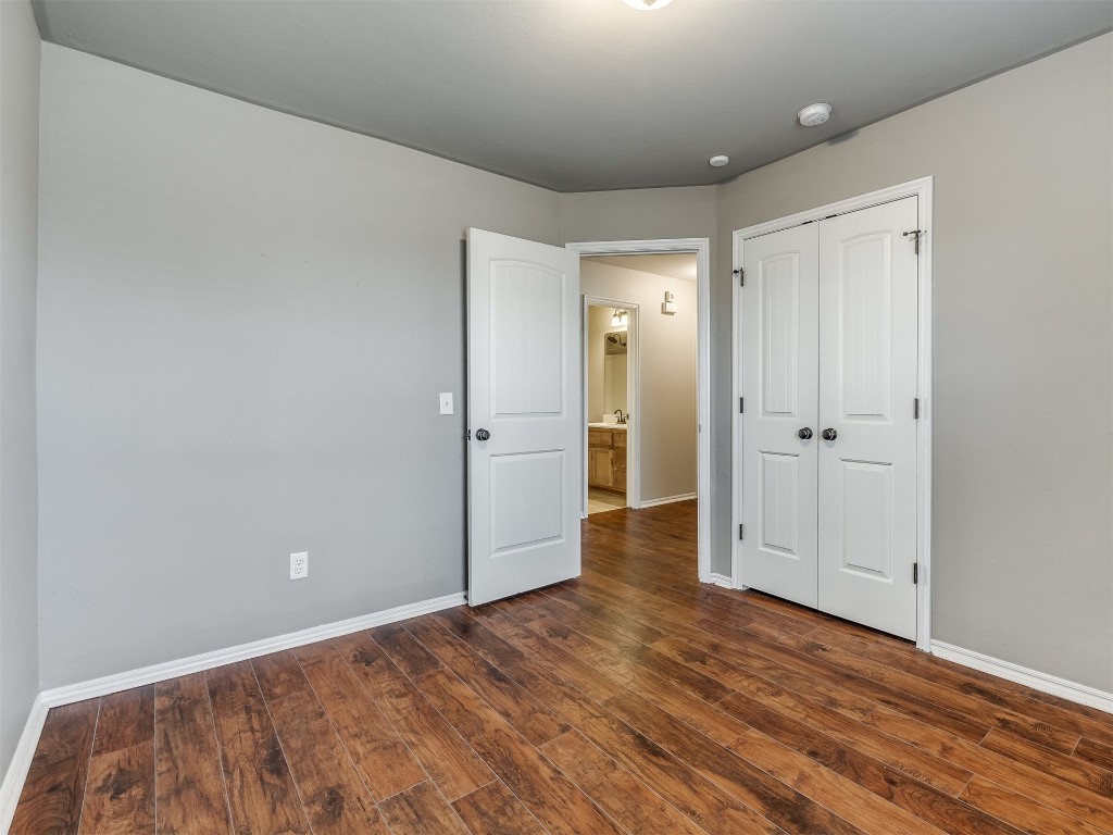 2333 NW 196th Terrace, Edmond, OK 73012 unfurnished bedroom with a closet and dark hardwood / wood-style floors