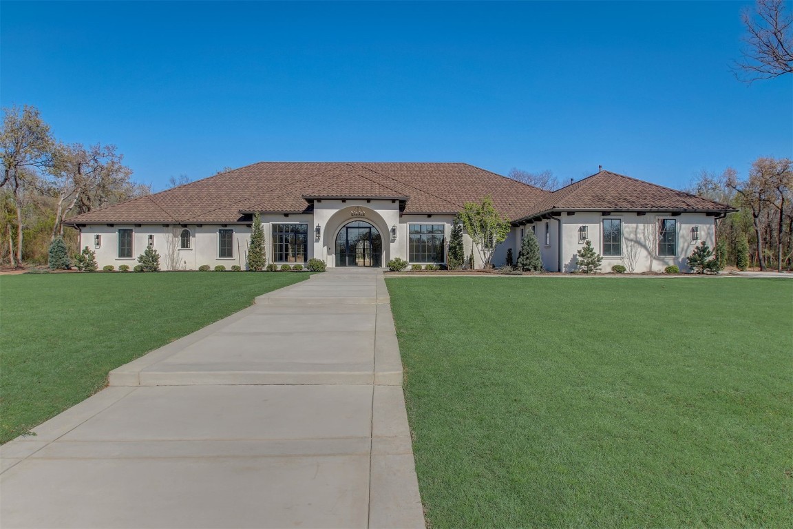 Welcome to this magnificent Spanish Revival estate nestled on 5 acres of pristine wooded land in Edmond Schools. This property seamlessly blends the elegance of Spanish architecture with modern luxury amenities. As you step inside, you'll be captivated by the expansive living room featuring a double-sided fireplace that opens to a cozy lounge area, creating a warm and inviting atmosphere for the entire family. The kitchen is a culinary dream come true, boasting a remarkable 60-inch commercial stove and a large central island, perfect for casual dining.The main residence offers 5 ensuite bedrooms, ensuring privacy and comfort for all family members. Additionally, a separate 763-square-foot guest home with its own bedroom, living area, and kitchenette is perfect for visitors or as a retreat space.This is included in the square footage. The grand groin ceiling in the entryway and the entertainment area with a wet bar in the game room are ideal for hosting guests and celebrating special moments. Movie night, anyone? We have a dedicated theater room for just that! The outdoor patio is an extension of indoor living, with a spacious layout, a firepit, and an outdoor kitchen, making it perfect
for family gatherings and social events.The stunning pool is a sight to behold, and the generous green space offers endless opportunities for outdoor activities.The master suite is a serene retreat with its own fireplace, a walk-around shower, a freestanding tub, and a gigantic closet that will delight any fashion enthusiast. Additionally, there's a butler's pantry for easy entertaining and catering.This residence is truly exceptional and offers a luxurious lifestyle amidst nature's beauty. Come and discover the unique charm and elegance of this Spanish-inspired property! With 6 bedrooms including the guest home and a 6 car garage,this home has room for everyone! Equestrian lover?Horses, barns and workshops allowed.Come see us at Parade of Homes starting April 19!