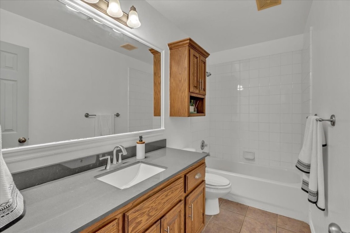 10320 Ashford Drive, Yukon, OK 73099 full bathroom with toilet, tile floors, vanity, and tiled shower / bath