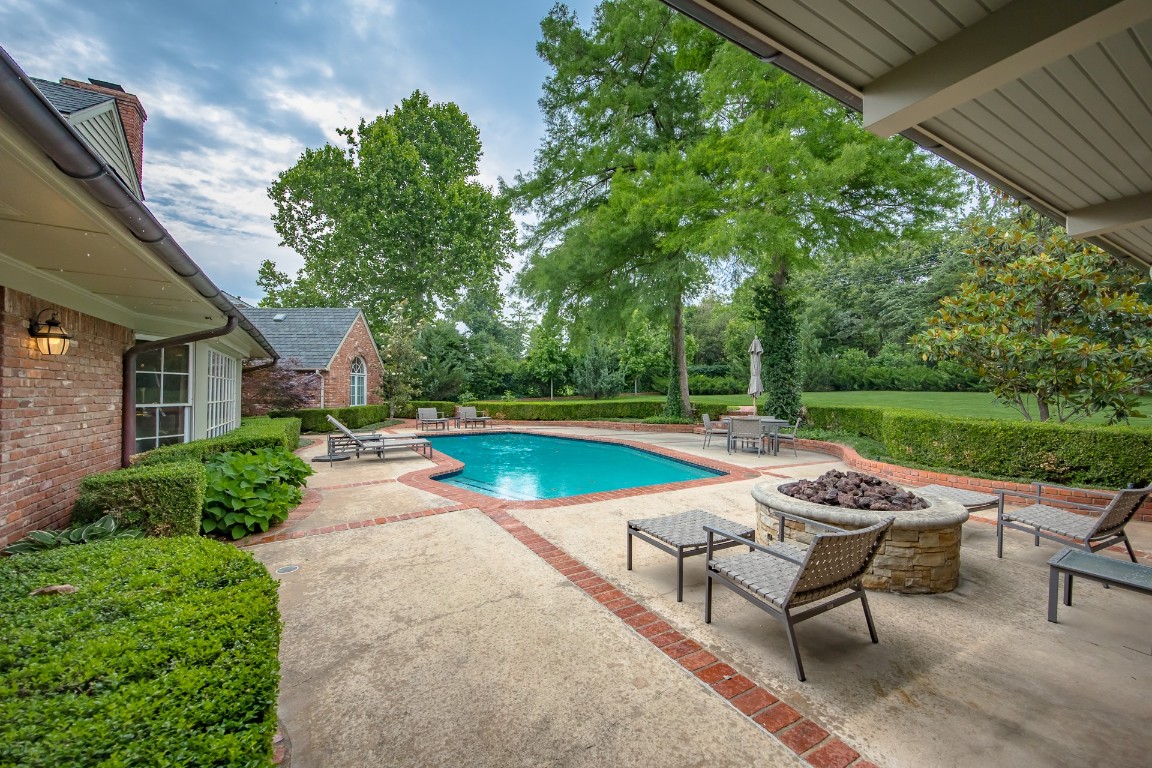 1601 Bedford Drive, Nichols Hills, OK 73116 view of swimming pool with a patio and an outdoor fire pit