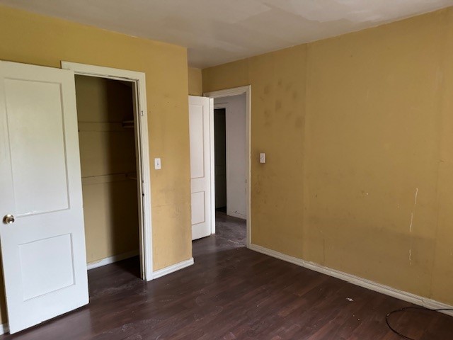 1713 N Quapah Avenue, Oklahoma City, OK 73107 unfurnished bedroom with dark hardwood / wood-style flooring and a closet