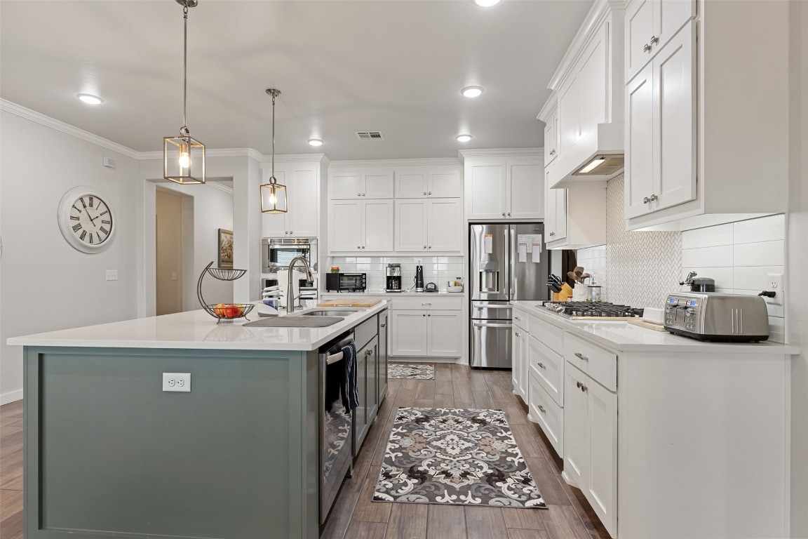 757 Acorn Bend, Piedmont, OK 73078 kitchen featuring decorative light fixtures, tasteful backsplash, and a kitchen island with sink