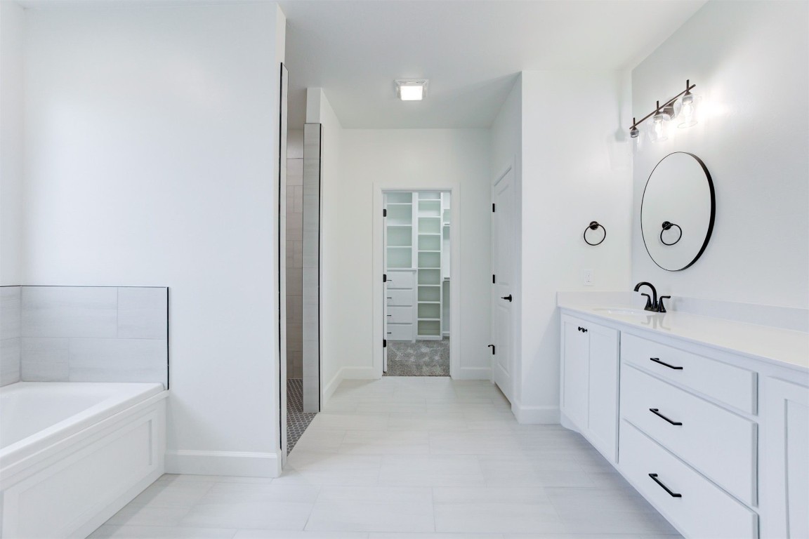 2004 Leo Court, Blanchard, OK 73010 bathroom featuring tile floors, a bathing tub, and large vanity