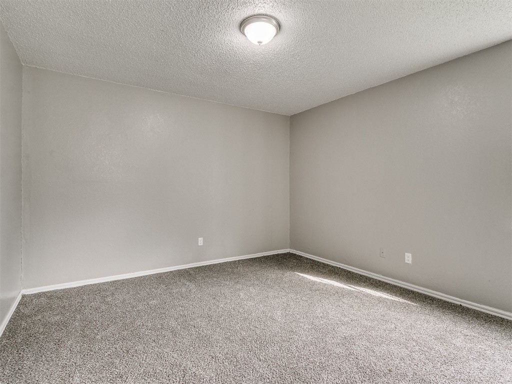 808 NW 113th Street, Oklahoma City, OK 73114 carpeted empty room featuring a textured ceiling