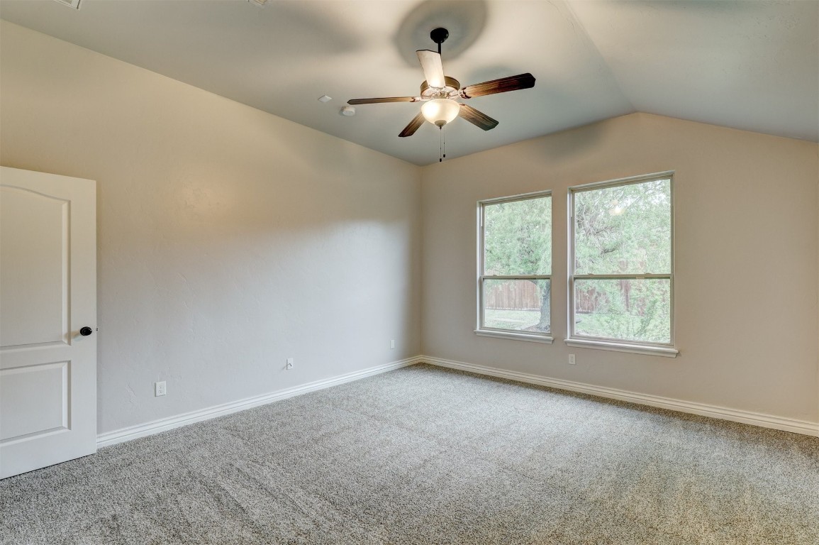 317 Partridge Run Road, Yukon, OK 73099 unfurnished room featuring ceiling fan, lofted ceiling, and light colored carpet