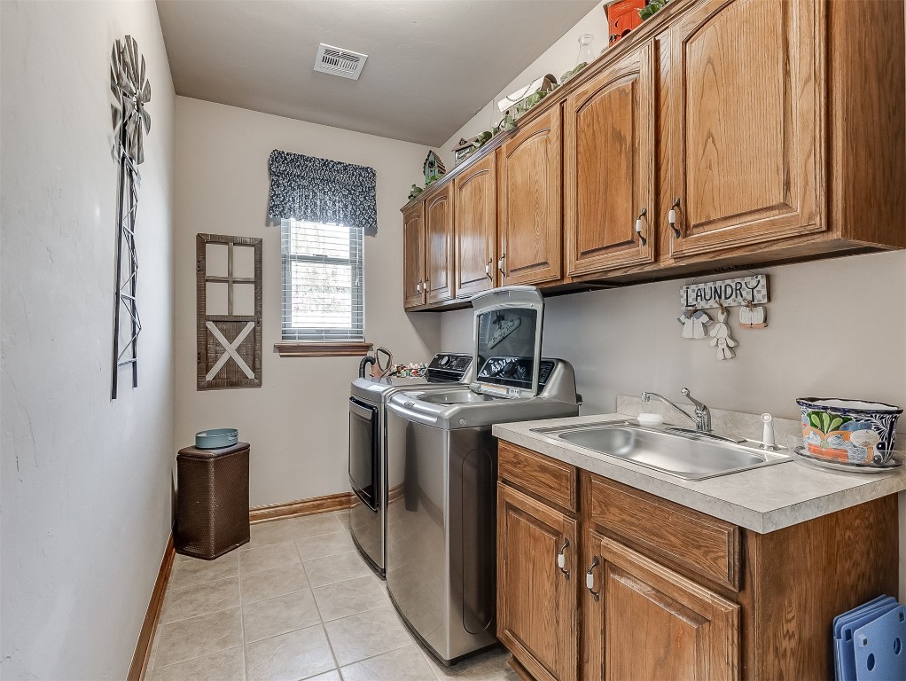 919 NW Fillmore Avenue NW Avenue, Piedmont, OK 73078 laundry room featuring sink, washer and clothes dryer, cabinets, and light tile floors