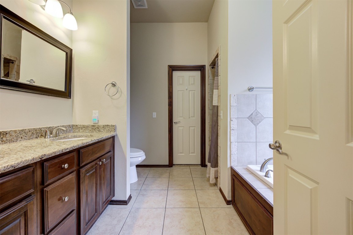 11748 SW 21st Street, Yukon, OK 73099 bathroom with vanity, toilet, and tile floors