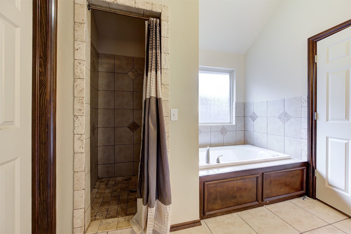 11748 SW 21st Street, Yukon, OK 73099 bathroom featuring lofted ceiling, tile flooring, and plus walk in shower