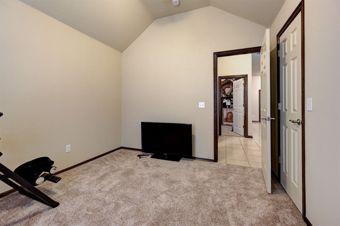 11748 SW 21st Street, Yukon, OK 73099 workout area featuring light tile flooring and lofted ceiling