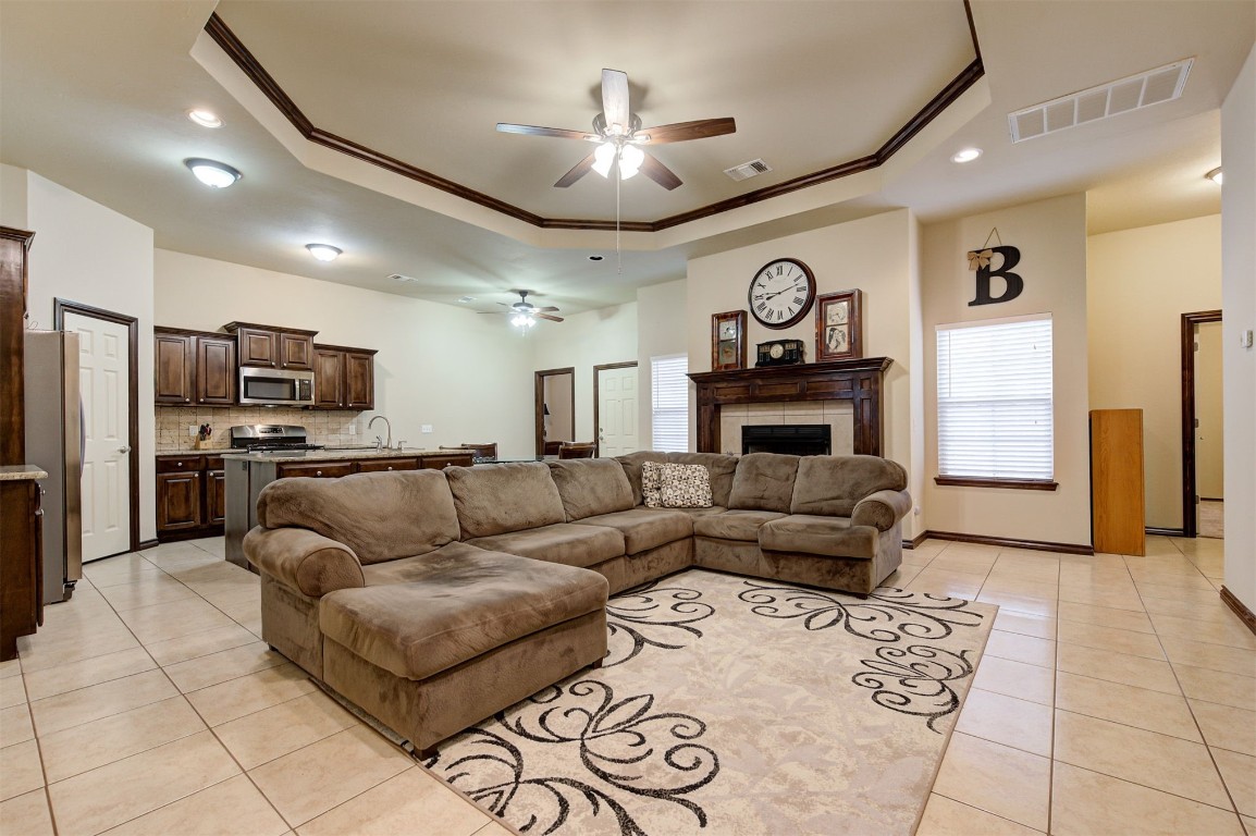 11748 SW 21st Street, Yukon, OK 73099 living room featuring sink, ceiling fan, a raised ceiling, and light tile flooring
