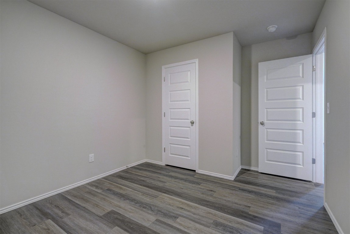 11920 Annette Drive, Yukon, OK 73099 unfurnished bedroom with a closet and dark wood-type flooring