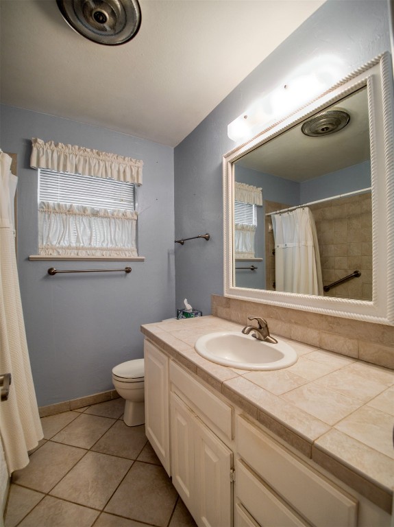 608 Skyline Drive, El Reno, OK 73036 bathroom featuring tile floors, toilet, vanity, and plenty of natural light
