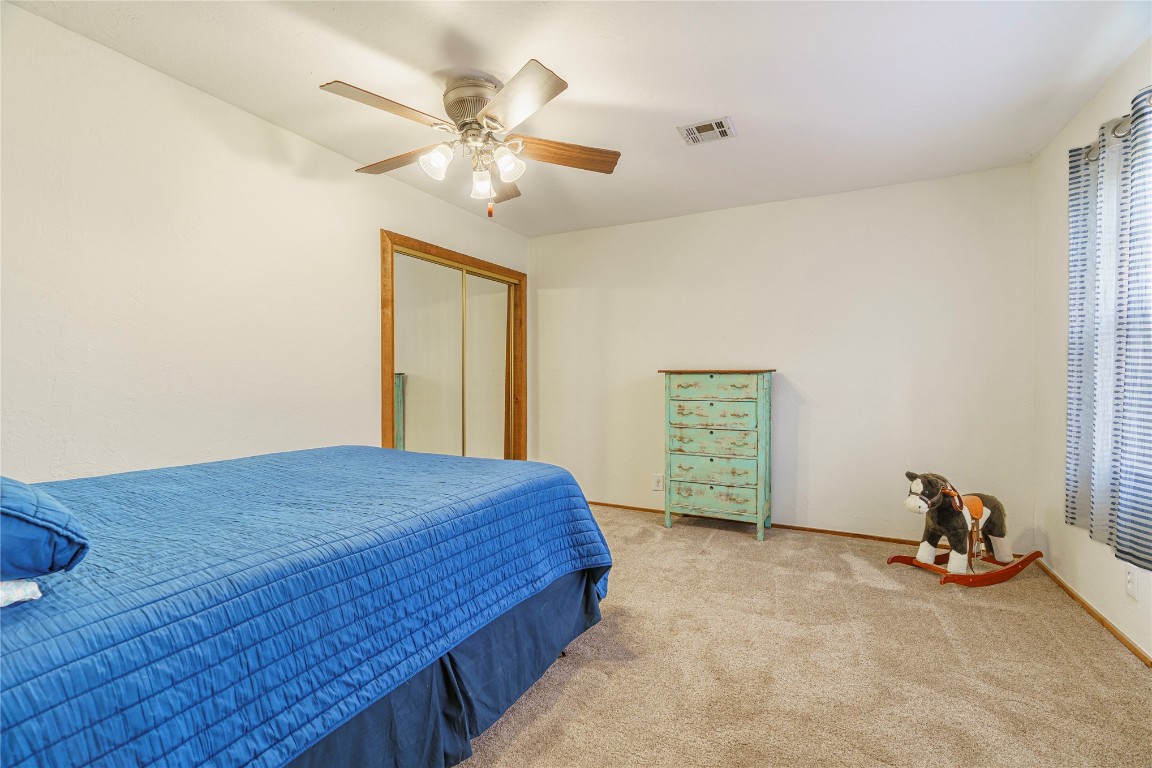 14655 NE 68th Street, Jones, OK 73049 bedroom with ceiling fan, a closet, and light carpet