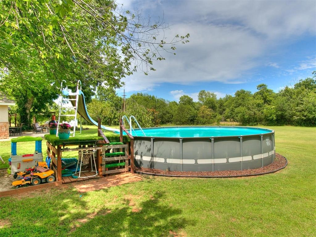 14655 NE 68th Street, Jones, OK 73049 view of pool with a water slide and a yard
