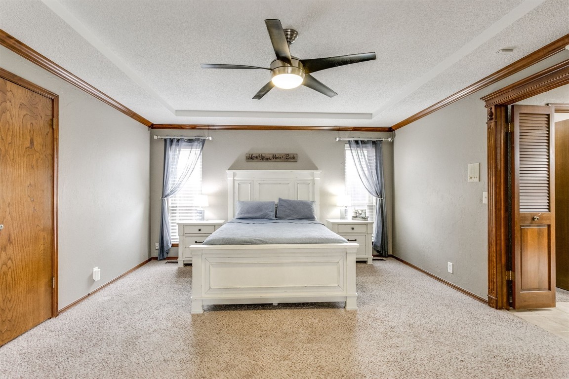 6201 Inland Road, Warr Acres, OK 73132 bedroom with ceiling fan, light carpet, and a textured ceiling