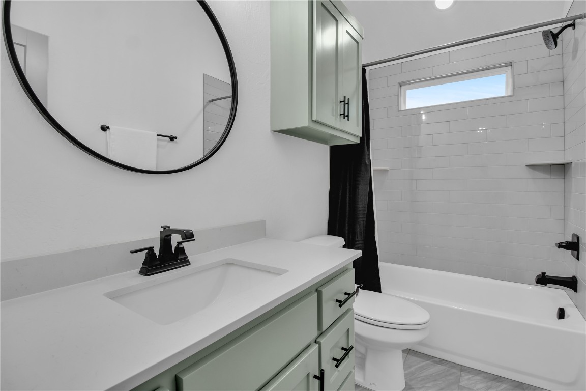 6516 NW 148th Street, Oklahoma City, OK 73142 full bathroom with large vanity, toilet, tiled shower / bath, and tile flooring