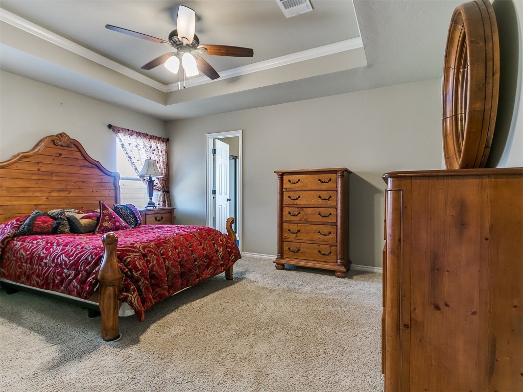 10012 Squire Lane, Yukon, OK 73099 carpeted bedroom featuring ceiling fan and a tray ceiling