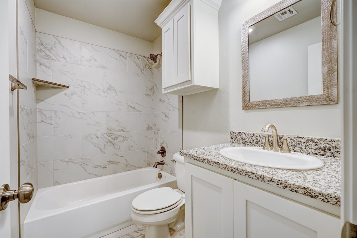 340 NW 97th Street, Oklahoma City, OK 73114 full bathroom with tiled shower / bath combo, vanity, and toilet