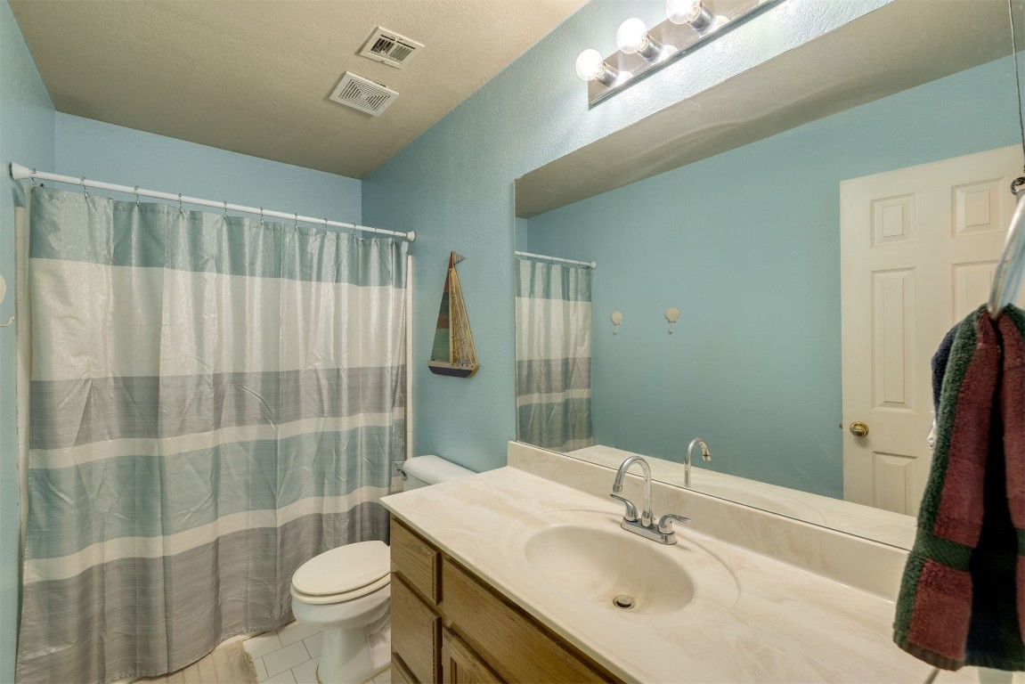 12104 N Dewey Avenue, Oklahoma City, OK 73114 bathroom featuring toilet, tile flooring, and large vanity