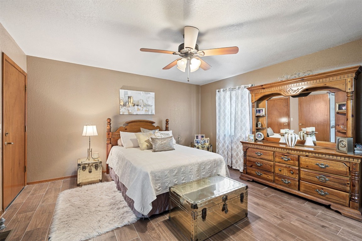 1524 W Oak Street, El Reno, OK 73036 bedroom with a textured ceiling, ceiling fan, and hardwood / wood-style floors