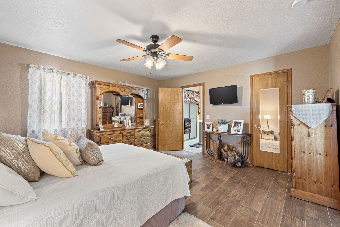 1524 W Oak Street, El Reno, OK 73036 bedroom featuring a closet, ceiling fan, a textured ceiling, dark wood-type flooring, and a spacious closet