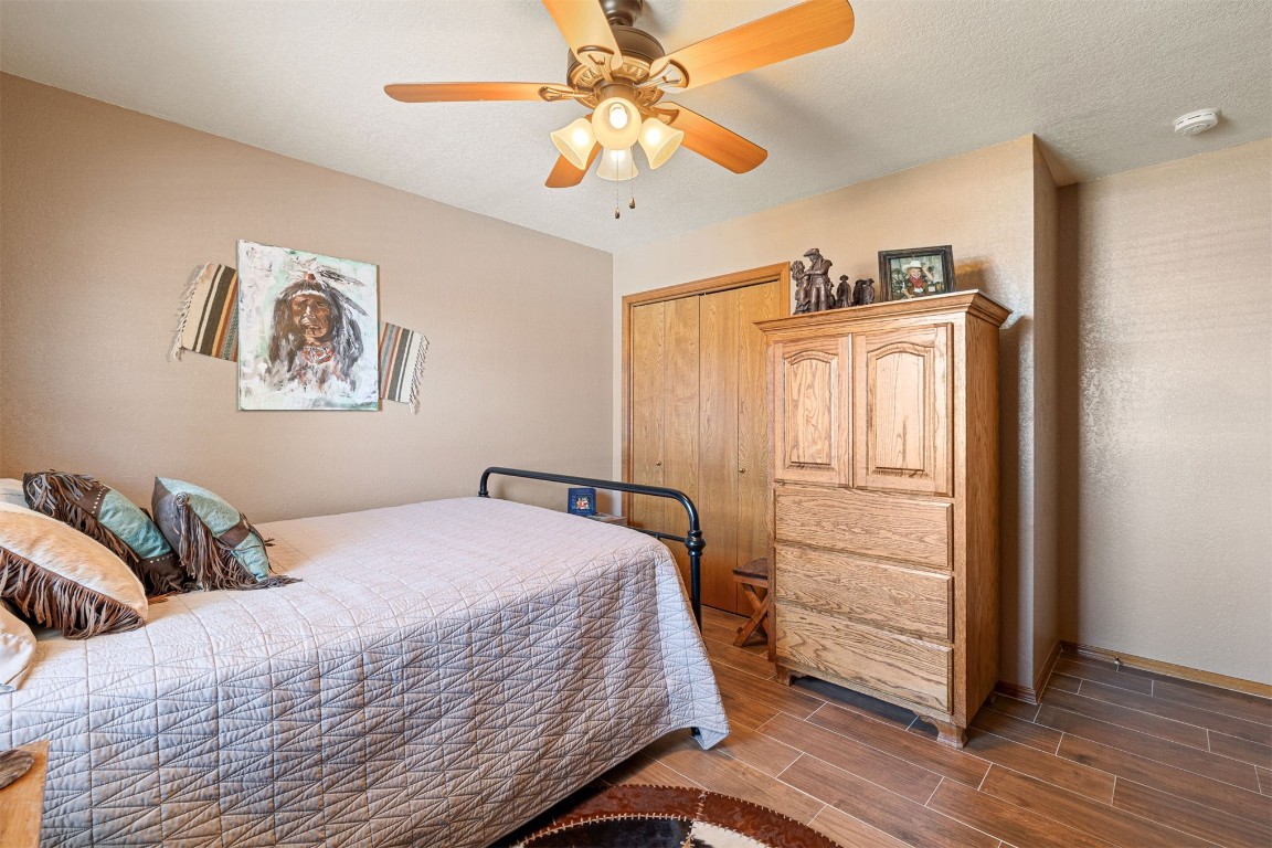 1524 W Oak Street, El Reno, OK 73036 bedroom featuring a closet, dark wood-type flooring, ceiling fan, and a textured ceiling