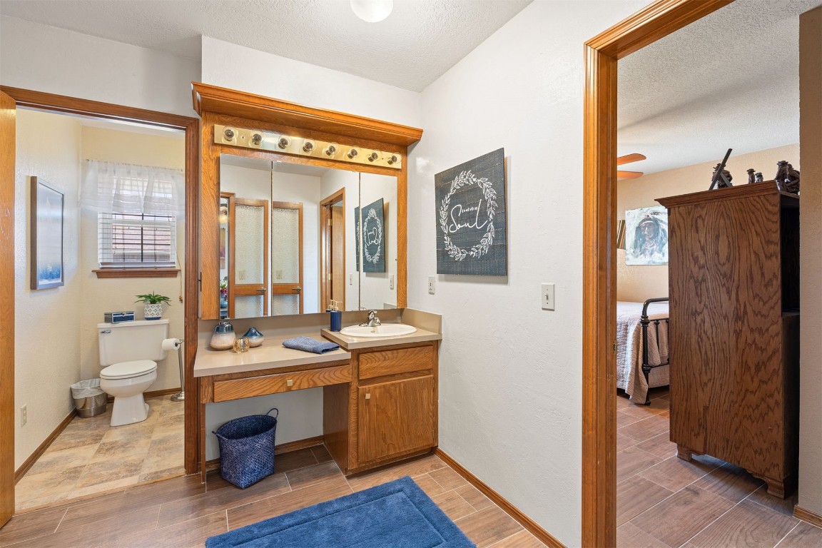 1524 W Oak Street, El Reno, OK 73036 bathroom with toilet, tile floors, a textured ceiling, and large vanity
