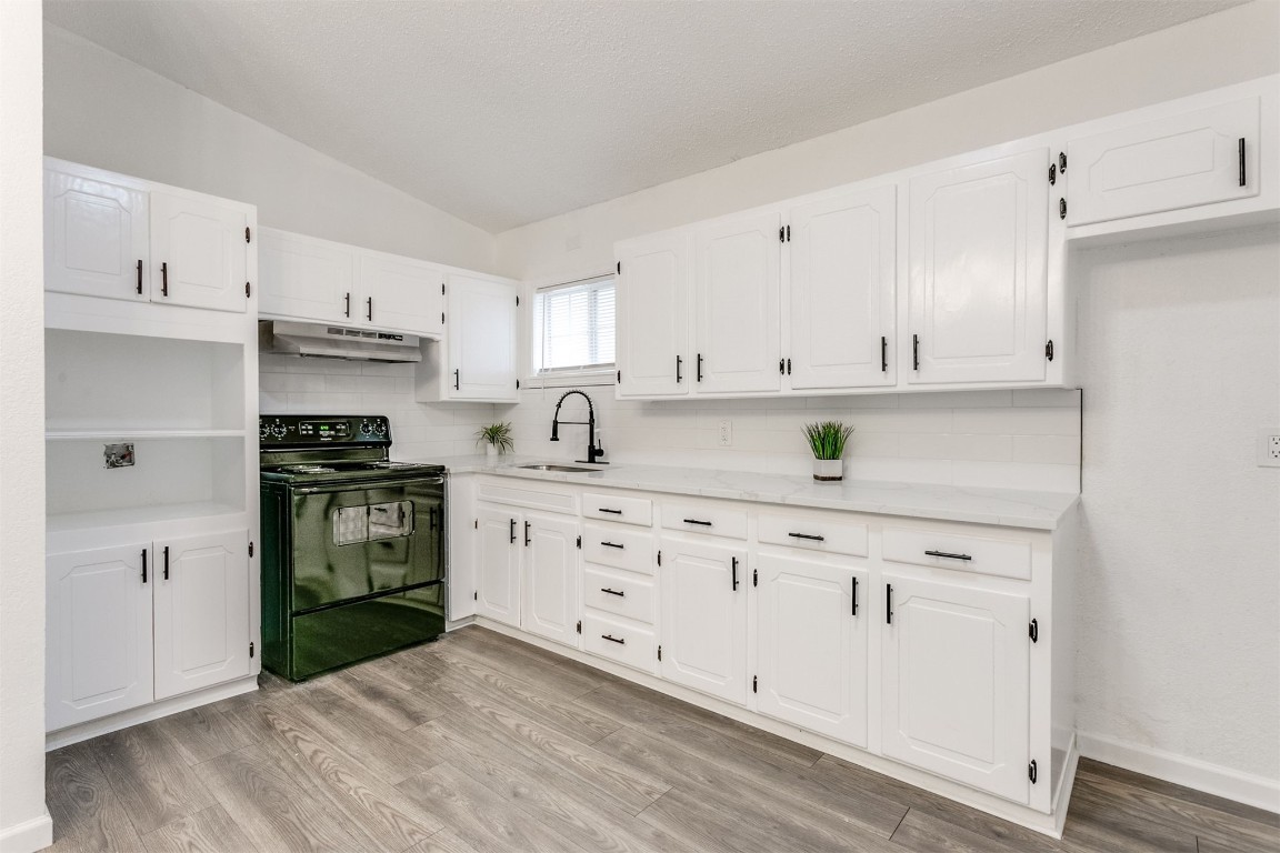 529 NW 92nd Street, Oklahoma City, OK 73114 kitchen featuring white cabinets, black range with electric stovetop, light hardwood / wood-style floors, and tasteful backsplash