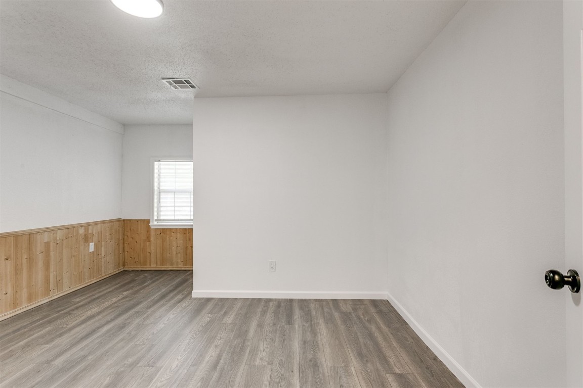 529 NW 92nd Street, Oklahoma City, OK 73114 spare room with a textured ceiling and hardwood / wood-style floors