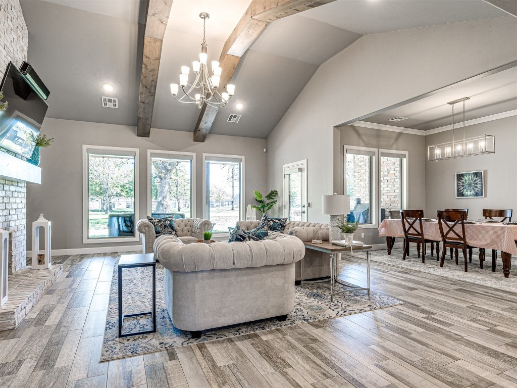1965 Ladera Lane, Edmond, OK 73034 living room with light hardwood / wood-style flooring, high vaulted ceiling, an inviting chandelier, and beam ceiling