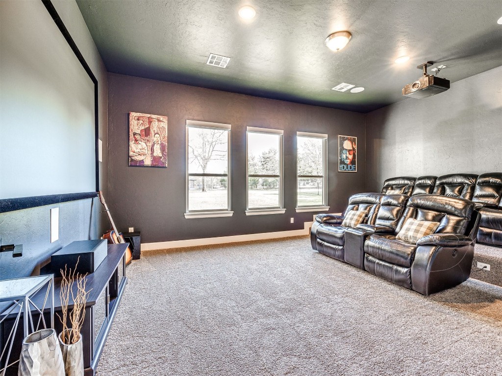1965 Ladera Lane, Edmond, OK 73034 home theater room with light carpet and a textured ceiling