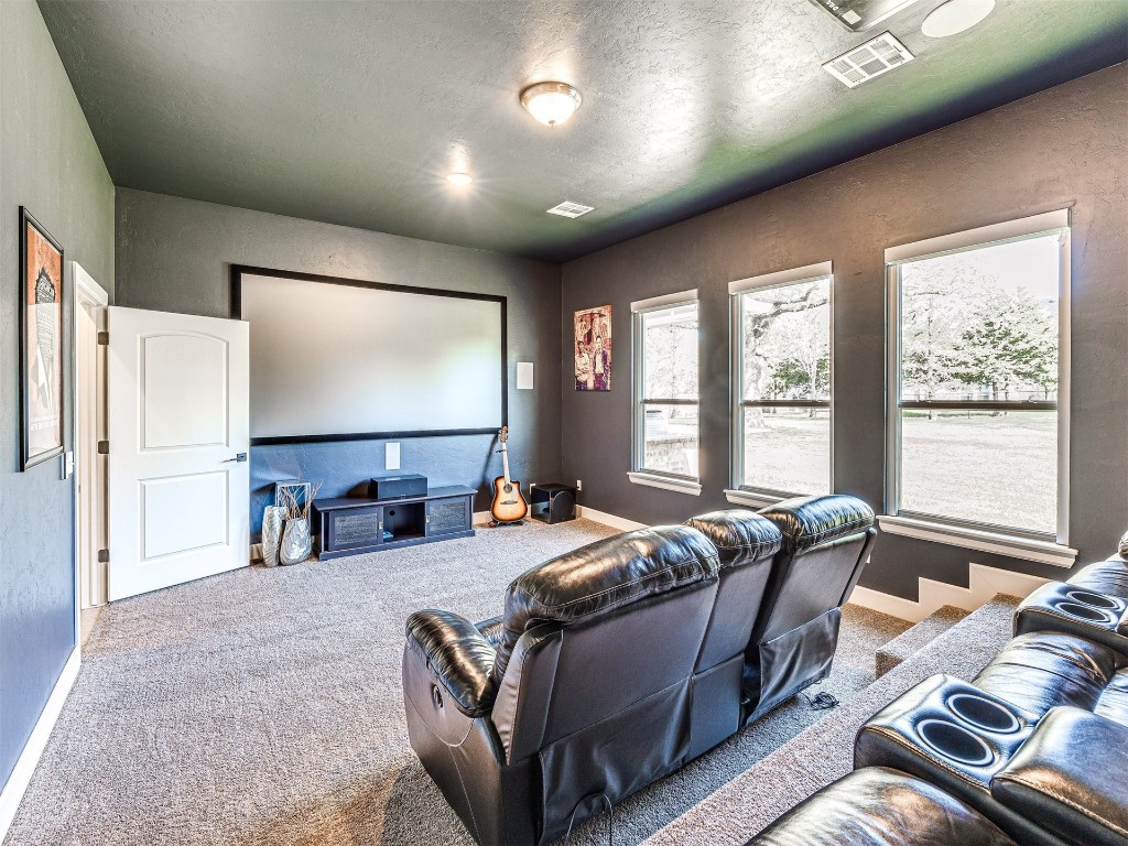 1965 Ladera Lane, Edmond, OK 73034 carpeted home theater featuring a textured ceiling