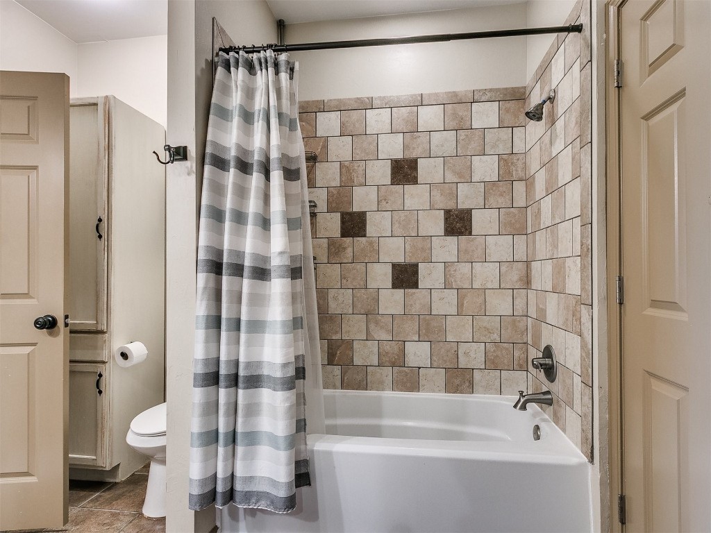 2350 Gina Court, Guthrie, OK 73044 bathroom featuring shower / bath combination with curtain, tile flooring, and toilet